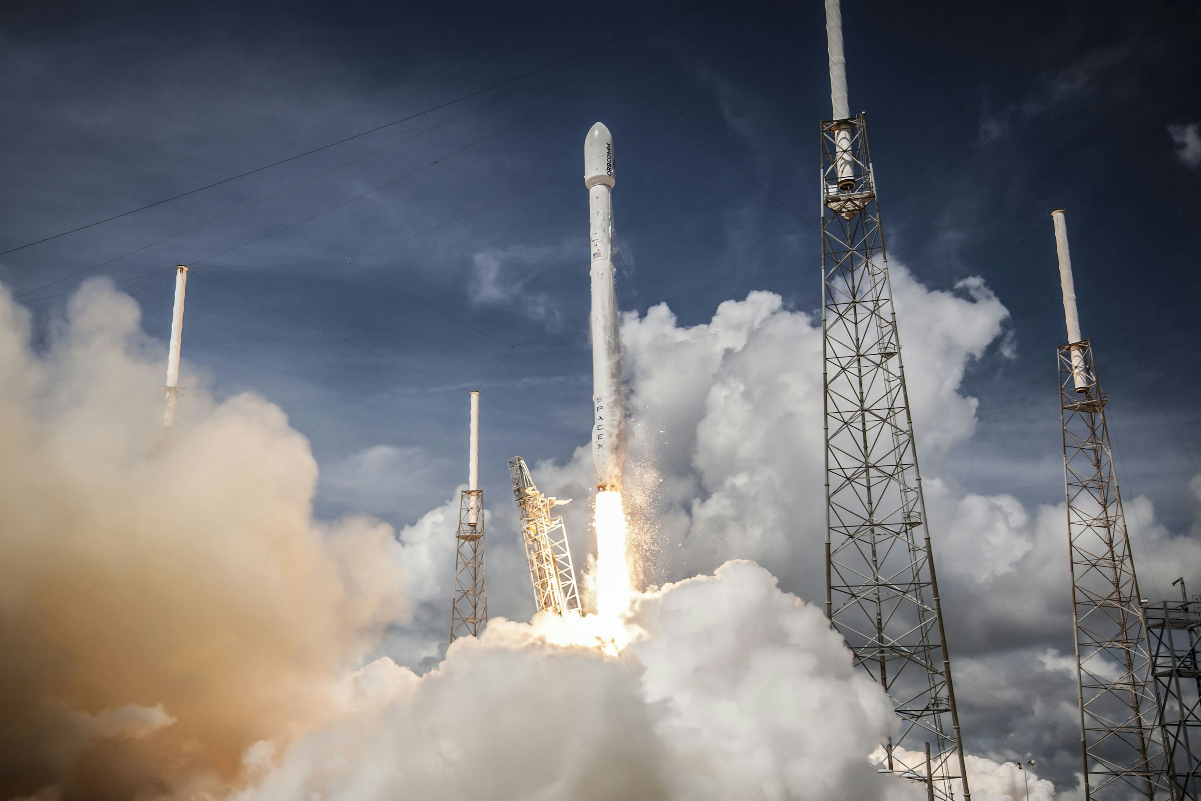 A rocket lifting off through a cloud of exhaust and fire